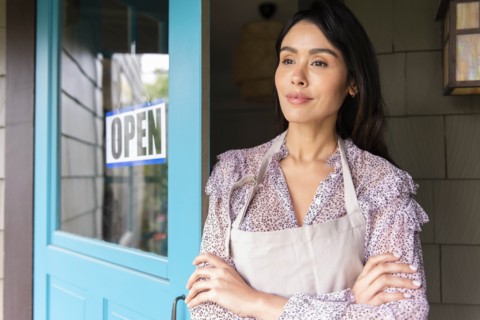 Woman by door to shop with open sign