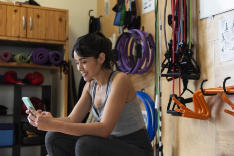 Woman using smart phone in gym
