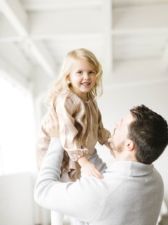 Mid adult man lifting his daughter