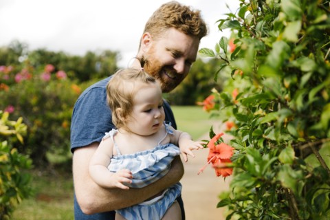 Man showing baby daughter flowers
