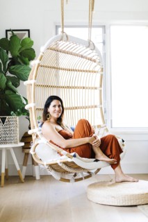Mid adult woman sitting on hanging chair