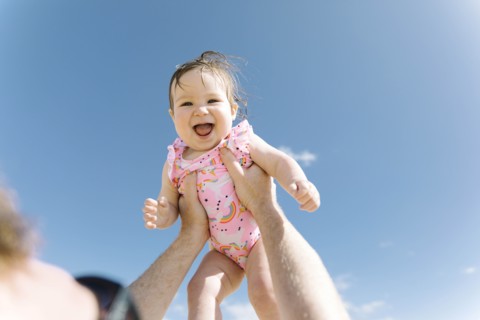 Father holding his baby girl aloft