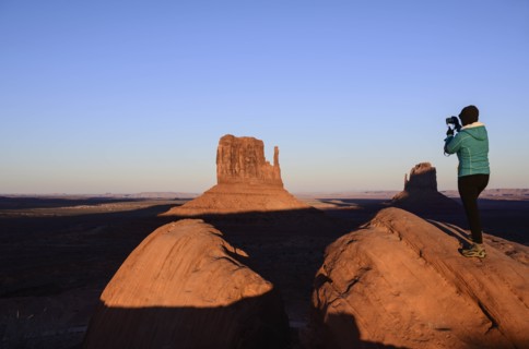 Woman photographing butte in Monument Valley, Arizona, USA