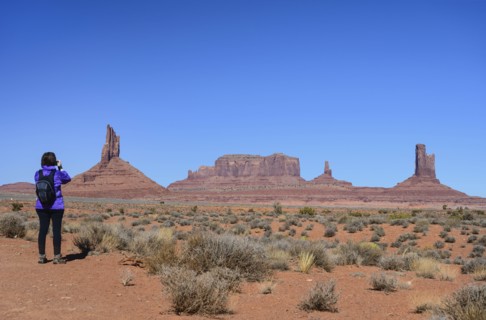 Woman wearing backpack by buttes in Monument Valley, Arizona, USA