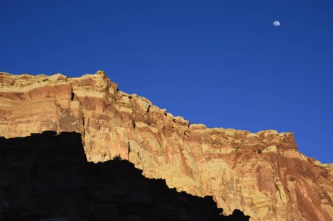 Moon over cliff in shadow in Capitol Reef National Park, USA