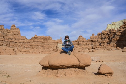 Woman meditating on rock in Goblin Valley State Park, Utah, USA