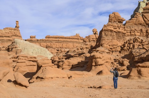 Woman photographing hoodoos in Goblin Valley State Park, Utah, USA