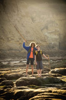 Teenage boys on rocks by tide pool in La Jolla, California