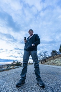 Low angle view of man holding smart phone on road