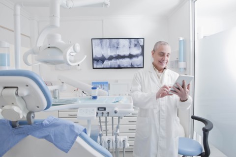 Dentist using digital tablet in dentist's surgery
