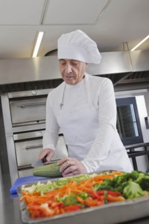 Chef slicing squash in commercial kitchen