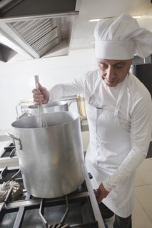 Chef using whisk in pot
