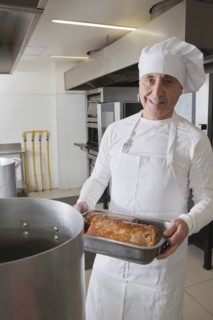 Chef holding meat in roasting tray