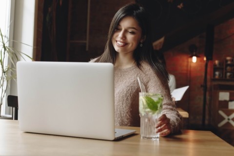 Woman sitting in restaurant with laptop