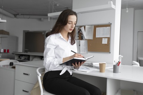 Fashion designer writing in notebook