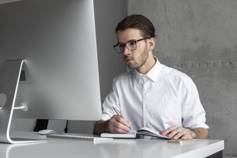 Businessman writing in note book
