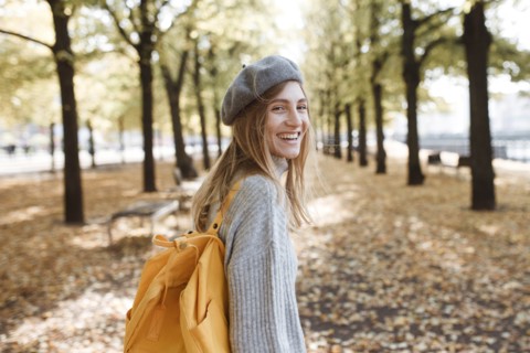 Young woman with yellow backpack in park in Berlin, Germany