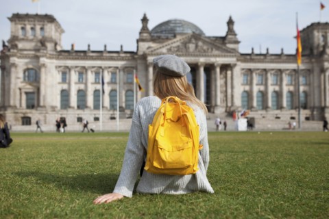 Young woman sitting in park by Reichstag in Berlin, Germany