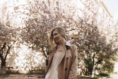 Smiling young woman by blossoming trees