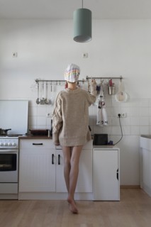 Rear view of young woman in apartment kitchen