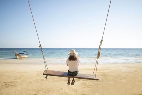 Young woman on swing at beach