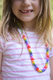 Smiling girl with missing tooth wearing necklace