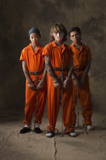 Boys in prisoner jumpsuits and handcuffs