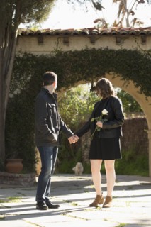 Young couple holding hands by arch