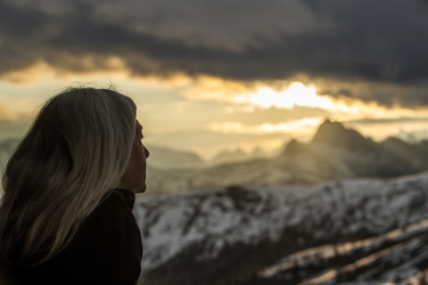 Mature woman by mountains at sunset in Dolomites, Italy