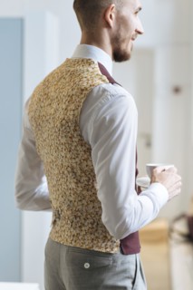 Man wearing patterned waistcoat holding tea cup