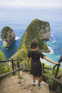 Woman on hillside steps above Kelingking Beach in Nusa Penida, Indonesia