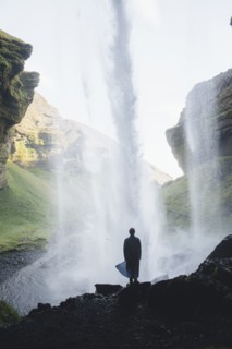 Silhouette of man behind Kvernufoss waterfall in Iceland