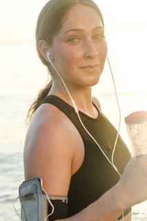 Woman wearing headphones holding water bottle