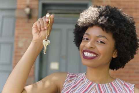Smiling young woman holding keys