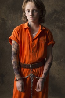 Boy in prisoner jumpsuit and handcuffs