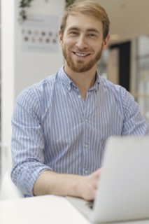 Smiling man using laptop