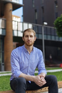 Man wearing striped shirt sitting on bench