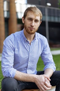Man wearing striped shirt sitting on bench