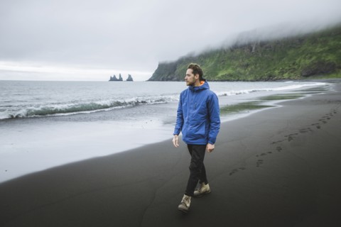 Man walking on beach in Vik, Iceland