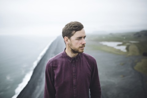 Bearded man above beach in Vik, Iceland