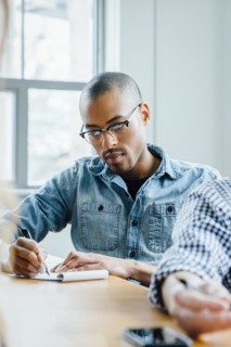 Man using note pad during meeting
