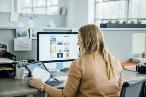 Woman using digital tablet and computer in office