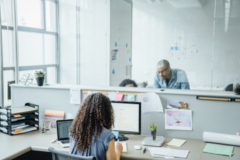 Woman using computer and laptop in office