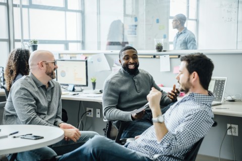 Men smiling during meeting in office
