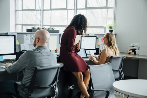 Coworkers talking at desk in office