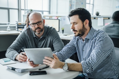 Men using digital tablet during meeting in office