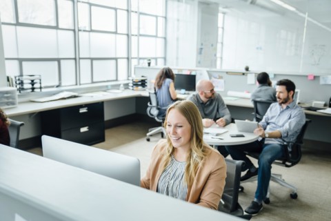 Smiling woman using computer in office