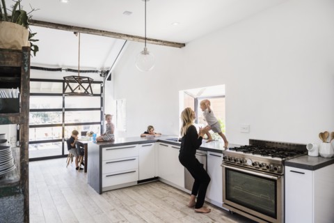 Mother catching son jumping off kitchen counter