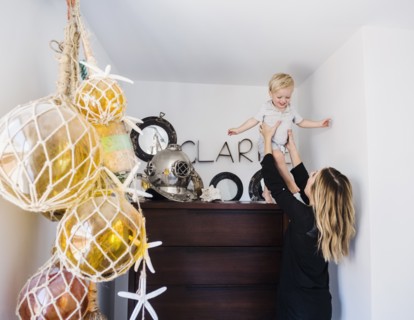 Mother holding son on top of drawers