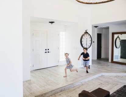 Boy chasing his sister in entrance hall